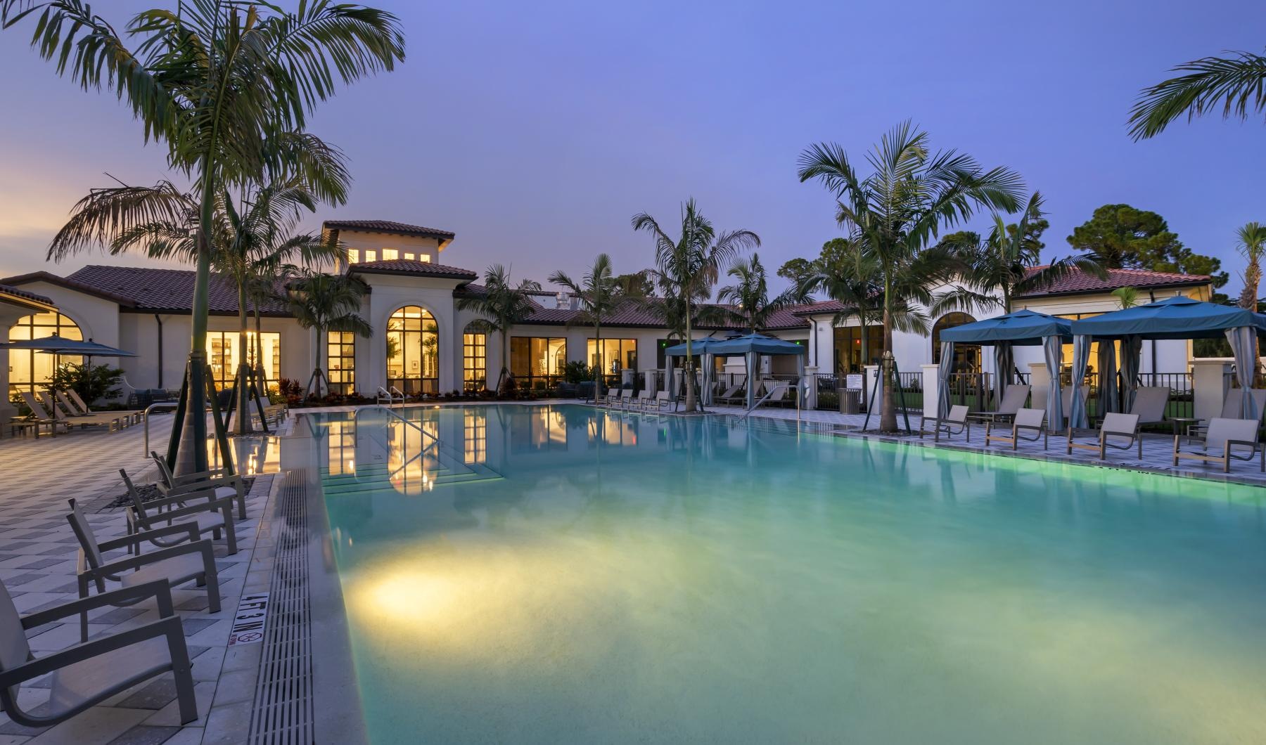 a swimming pool with lounge chairs and a building in a courtyard