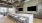 a kitchen with tv's a bar and stools