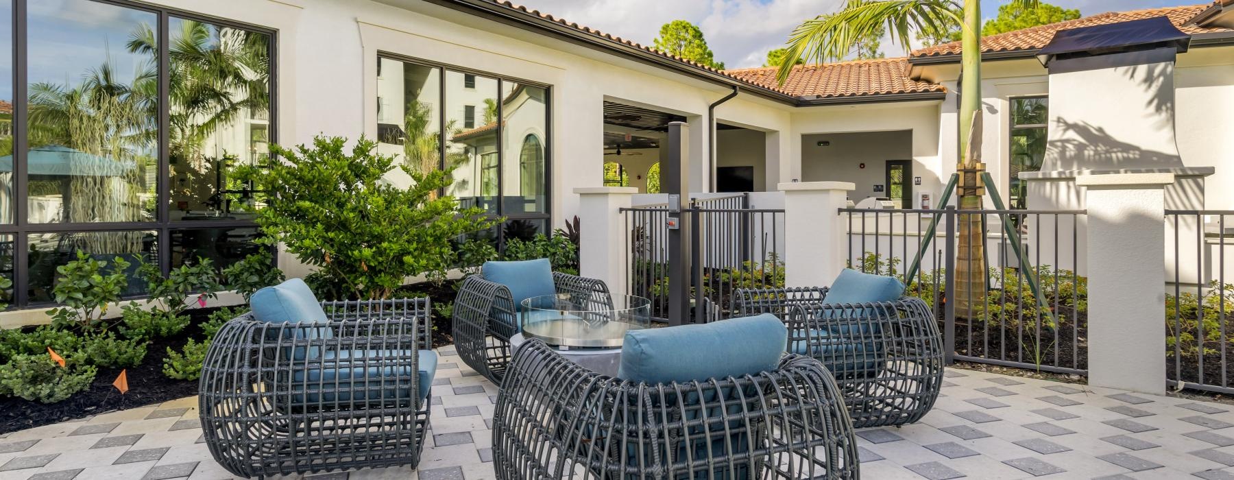 a patio with chairs and tables outside a building