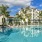 a pool with palm trees and a building in the background