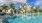 a pool with palm trees and a building in the background