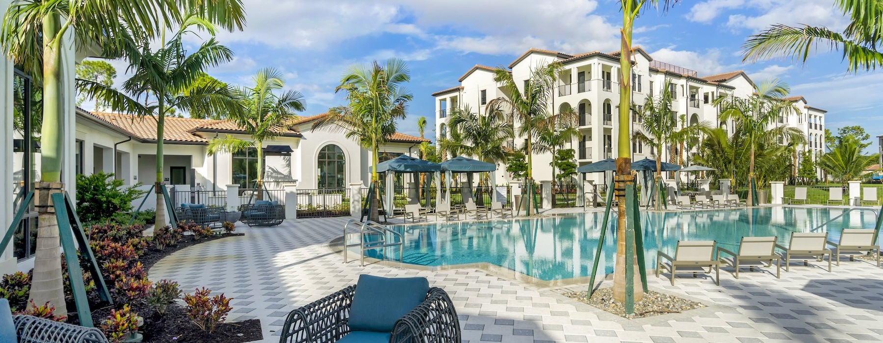 resort style pool with seating and a building behind